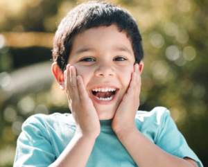Primer plano de la dentición infantil mostrando un incisivo permanente erupcionando detrás de un diente de leche en la arcada inferior
