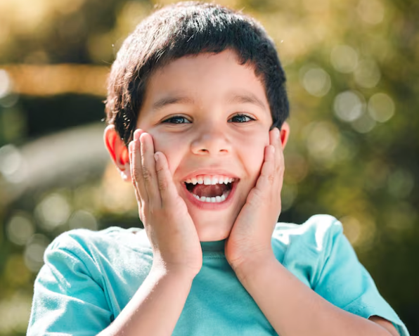 Primer plano de la dentición infantil mostrando un incisivo permanente erupcionando detrás de un diente de leche en la arcada inferior